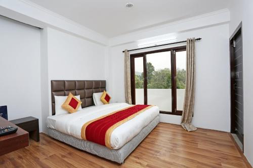 sypialnia z łóżkiem i dużym oknem w obiekcie Summer King w mieście Nainital