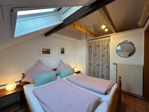 sypialnia z dużym łóżkiem i oknem dachowym w obiekcie Landhaus up de Warft - Backhaus w mieście Werdum