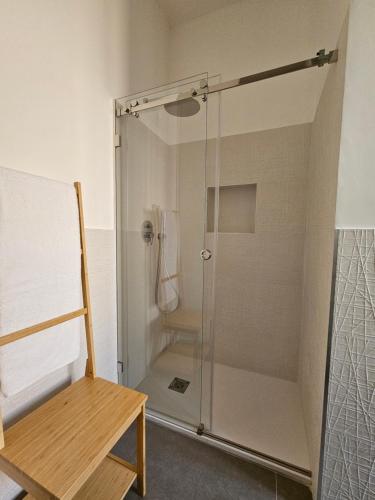 a shower with a glass door next to a bench at Pangea - Asia in Trani