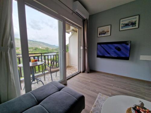a living room with a couch and a large window at Studio apartmani Milović in Trebinje