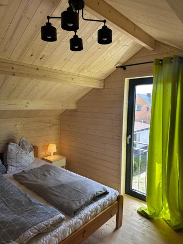 sypialnia z łóżkiem w pokoju z oknem w obiekcie Chatki nad wodnym zakątkiem. w mieście Wapnica