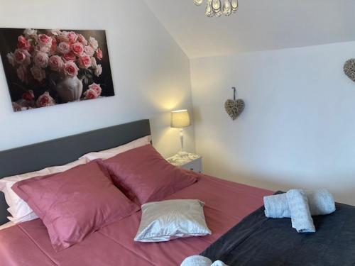 een slaapkamer met een groot bed met roze kussens bij Chambre d'Hôtes Salamandre in Lanvollon
