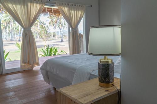 sypialnia z łóżkiem i lampką na stole w obiekcie Sumba Retreat Kerewe w Waikabubak