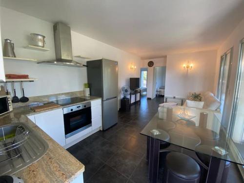 une cuisine avec une table et un comptoir dans l'établissement Appartement T4 - 50m de la mer, à Pietrosella