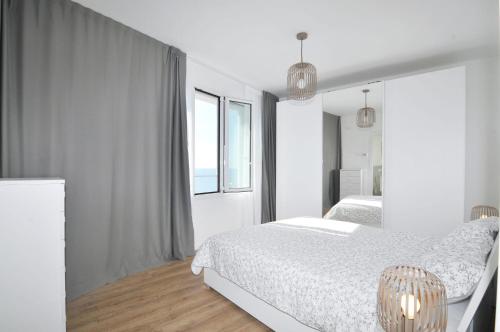 a white bedroom with a bed and a window at Bellavista in Caorle