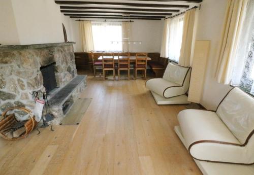 un salon avec une cheminée en pierre et une table dans l'établissement Schwarzwaldhaus Sonnenstraße, Oberried-Hofsgrund, Dreisamtal, à Oberried