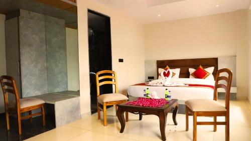 Un dormitorio con una cama y una mesa con flores. en Hotel Kamakhya Inn By BookingCare, en Chhatarpur