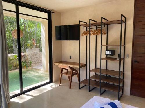 Habitación con escritorio, mesa y ventana. en Little Oasis with private pool in the jungle, en Chemuyil