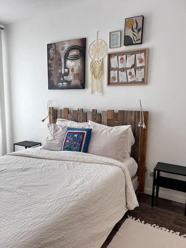 - une chambre avec un lit et des photos sur le mur dans l'établissement Maison cosy. Mandres, à Mandres-les-Roses