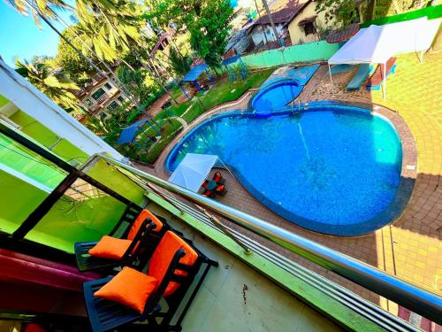 an overhead view of a swimming pool with two chairs at Hamilton Hotel & Resort Goa in Goa