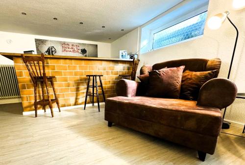 sala de estar con sofá marrón y bar en TULIP PATH 3, Ferien & Monteur Wohnung Melle, en Melle