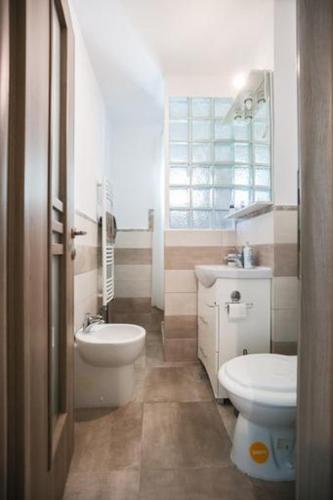 a bathroom with a sink and a toilet and a window at BIUTI in Târgu-Mureş