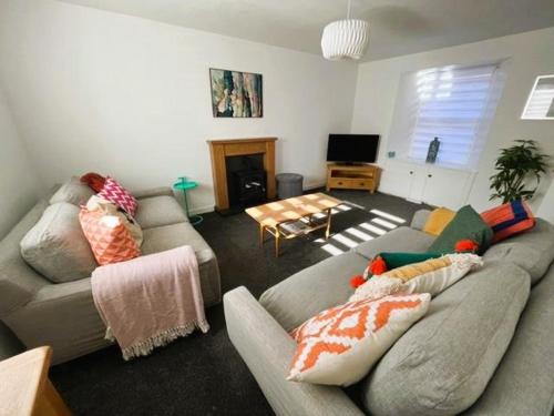 uma sala de estar com dois sofás e uma televisão em Dookers Nook- Quirky coastal cottage Pittenweem em Pittenweem