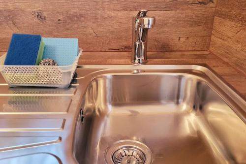 a kitchen sink with a faucet and some soap at Colourful 2.5 Bedroom With Large Balcony & Garden. in Prinzersdorf
