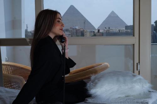 een vrouw die in een stoel zit te praten op een microfoon bij The Muse Pyramids INN in Caïro