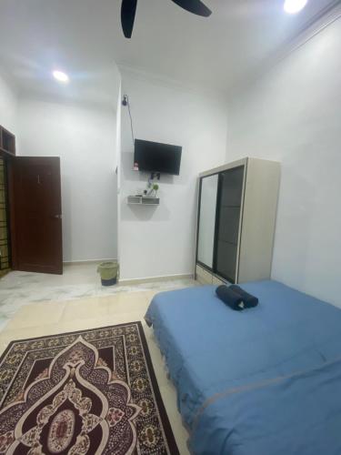 a bedroom with a bed and a tv in it at KZ Roomstay in Kuala Terengganu