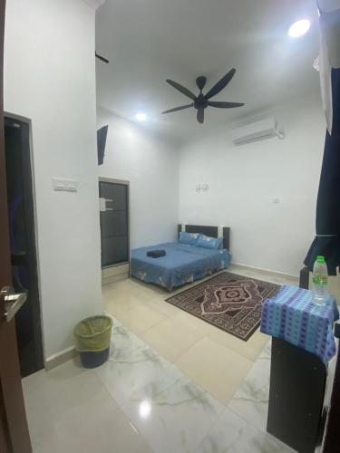a room with a bed and a ceiling fan at KZ Roomstay in Kuala Terengganu