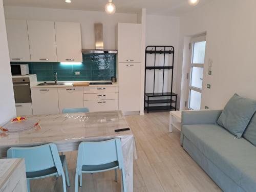 cocina y sala de estar con mesa y sofá en Conca d'oro B&B and Apartments, en Nago-Torbole