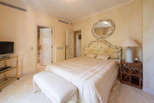 Un dormitorio con una cama grande y un espejo. en Villa de luxe à Cap-d'Ail, en Saint-Antoine