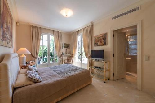 une chambre avec un grand lit et une télévision dans l'établissement Villa de luxe à Cap-d'Ail, à Saint-Antoine