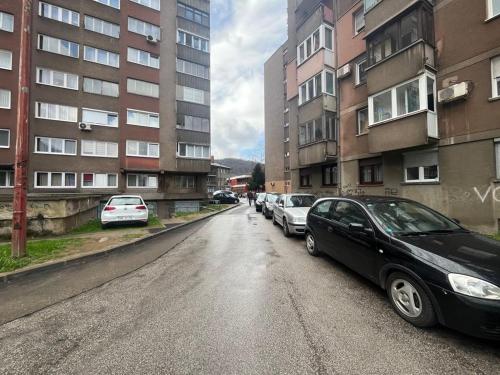 una strada con auto parcheggiate sui lati degli edifici di OPTIMUM 1 apartment - One bedroom - in core city center a Zenica