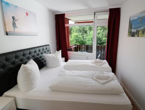 a bedroom with two beds and a window at Kurhotel Schluchsee App 1321 - Schwarzwälder Kirsch - mit Indoorpool, Schluchsee in Schluchsee