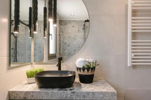 een badkamer met een zwarte wastafel en een spiegel bij APARKTION THE ZEPHYRUS STUDIO in Lixouri