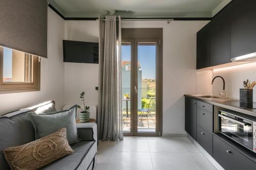 een woonkamer met een bank en een keuken bij APARKTION THE ZEPHYRUS STUDIO in Lixouri