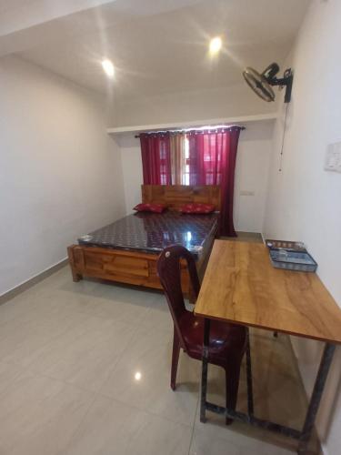 a room with a desk and a chair and a table at Whitehouse Homestay-Iqra Hospital Calicut in Kozhikode