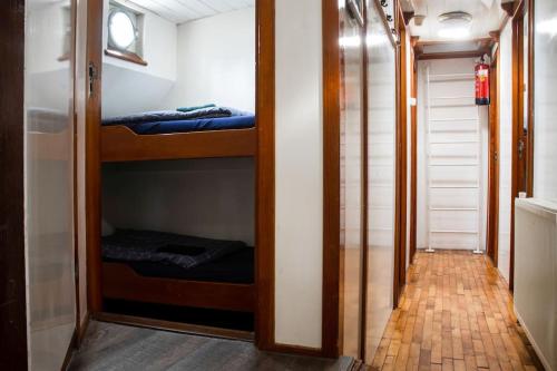 Un pasillo con dos literas en una habitación. en Uniek verblijf op slaapschip (tot 20 personen) nabij het centrum van Leeuwarden, en Leeuwarden