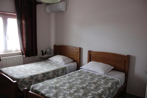 2 camas en un dormitorio pequeño con ventana en Quinta de São Marcos, en Fundão