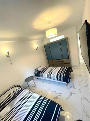un dormitorio con dos camas y un televisor en Evasion Cannoise, en Cannes