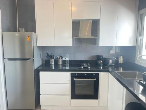 a kitchen with white cabinets and a refrigerator at Stanza Mare Beach Front in Punta Cana