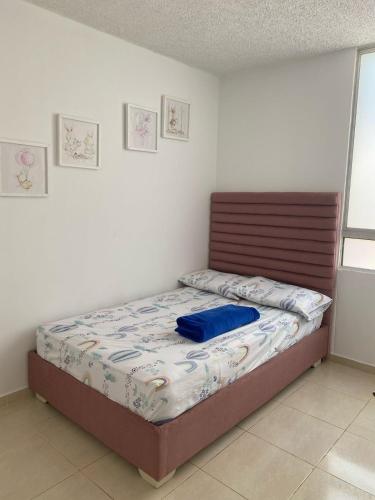 een slaapkamer met een bed met een blauw kussen erop bij APARTAMENTO COMPLETO 3 HABITACIONES - 2 AIRE ACONDICIONADOS in Valledupar