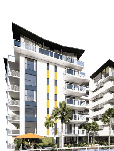 an apartment building with palm trees in front of it at Brandons at the Pavilion Cantonments in Accra