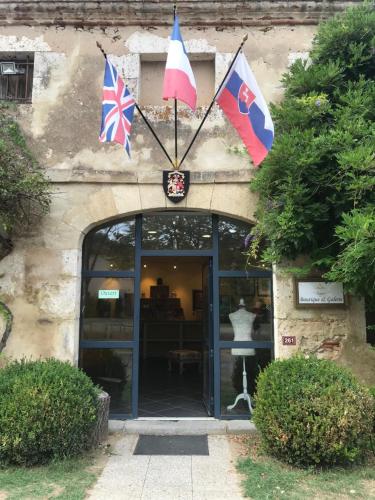 a building with flags in front of a door at Chateau De Grenier Apartment in Saint-Léger