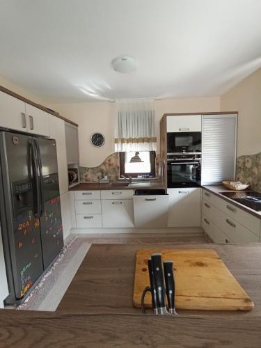 a kitchen with white cabinets and a wooden cutting board at Villa Lake in Konjic