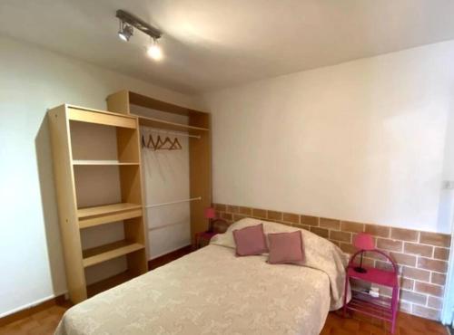 une chambre avec un lit et une étagère dans l'établissement Appartement T2 n°3 - proche plage, à Pietrosella