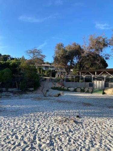 une plage de sable avec une maison en arrière-plan dans l'établissement Appartement T2 n°3 - proche plage, à Pietrosella