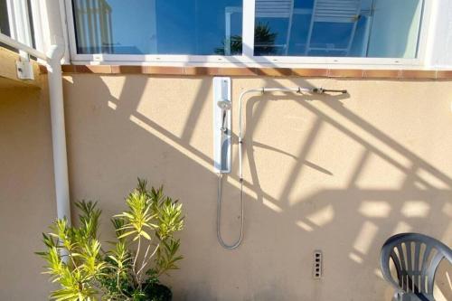 l'ombre d'une douche sur le côté d'un bâtiment dans l'établissement Appartement T2 n°3 - proche plage, à Pietrosella