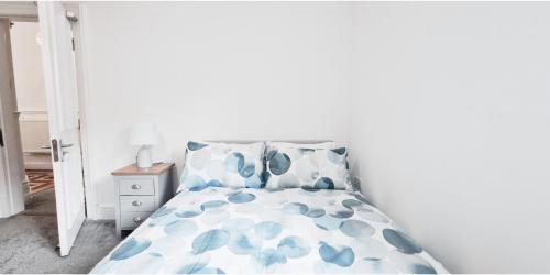 Un dormitorio con una cama con almohadas azules y blancas. en Lovely Room at The Burford Hideaway, en Nottingham