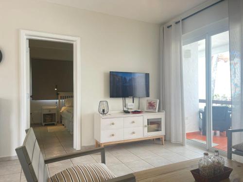 a living room with a television on a dresser at Stanza Mare Beach Front in Punta Cana
