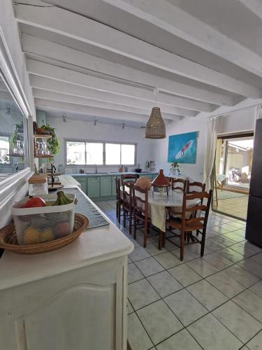 une cuisine et une salle à manger avec une table et des chaises dans l'établissement AigaSurfHouse, à Azur