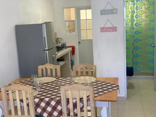 uma cozinha com uma mesa e cadeiras e um frigorífico em Tranquilo y cómodo em Playa del Carmen