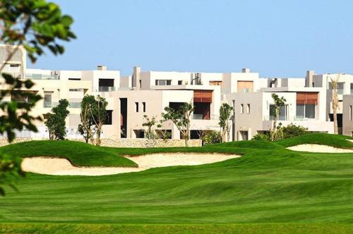 un campo da golf con un grande edificio sullo sfondo di Hacienda Bay Chalet Sidi Abdelrahman North Coast a El Alamein
