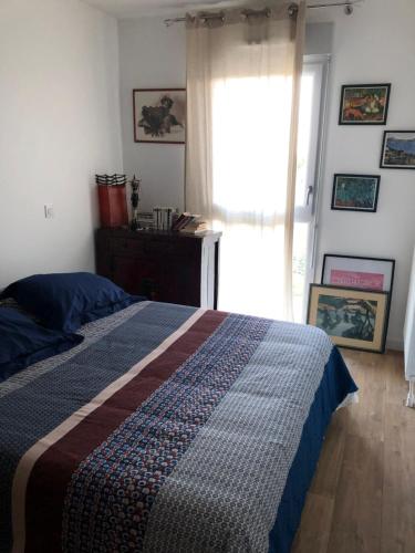 une chambre avec un lit et une grande fenêtre dans l'établissement Les flots de Cancale, à Cancale