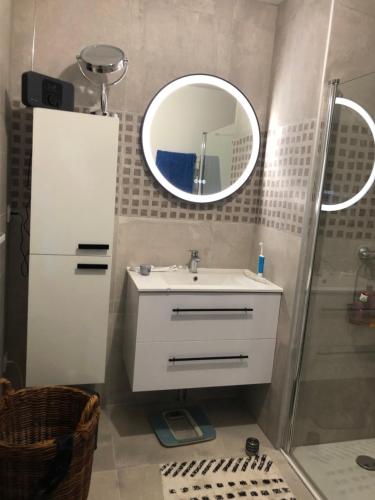 une salle de bain avec un lavabo et un miroir dans l'établissement Les flots de Cancale, à Cancale