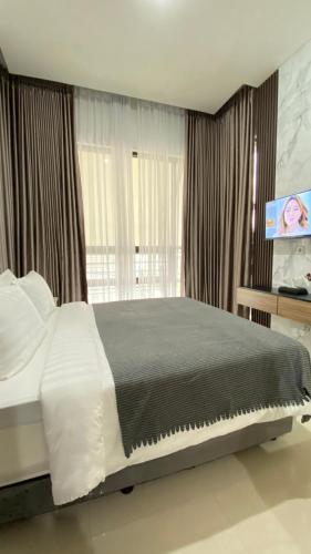 a bedroom with a large bed and a flat screen tv at Mallory Villa in Batu