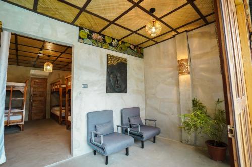 two blue chairs sitting in a room with a wall at Marika Resort in Badian