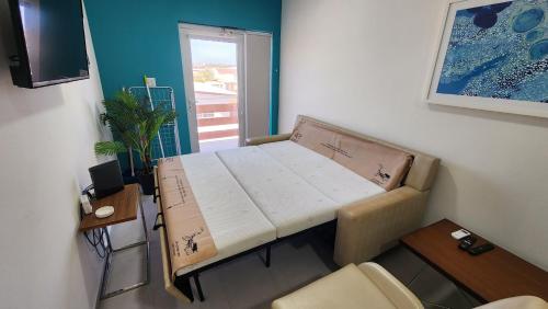 a small room with a bed in the corner of a room at Ocean Breeze Apartments in Aruba in Oranjestad